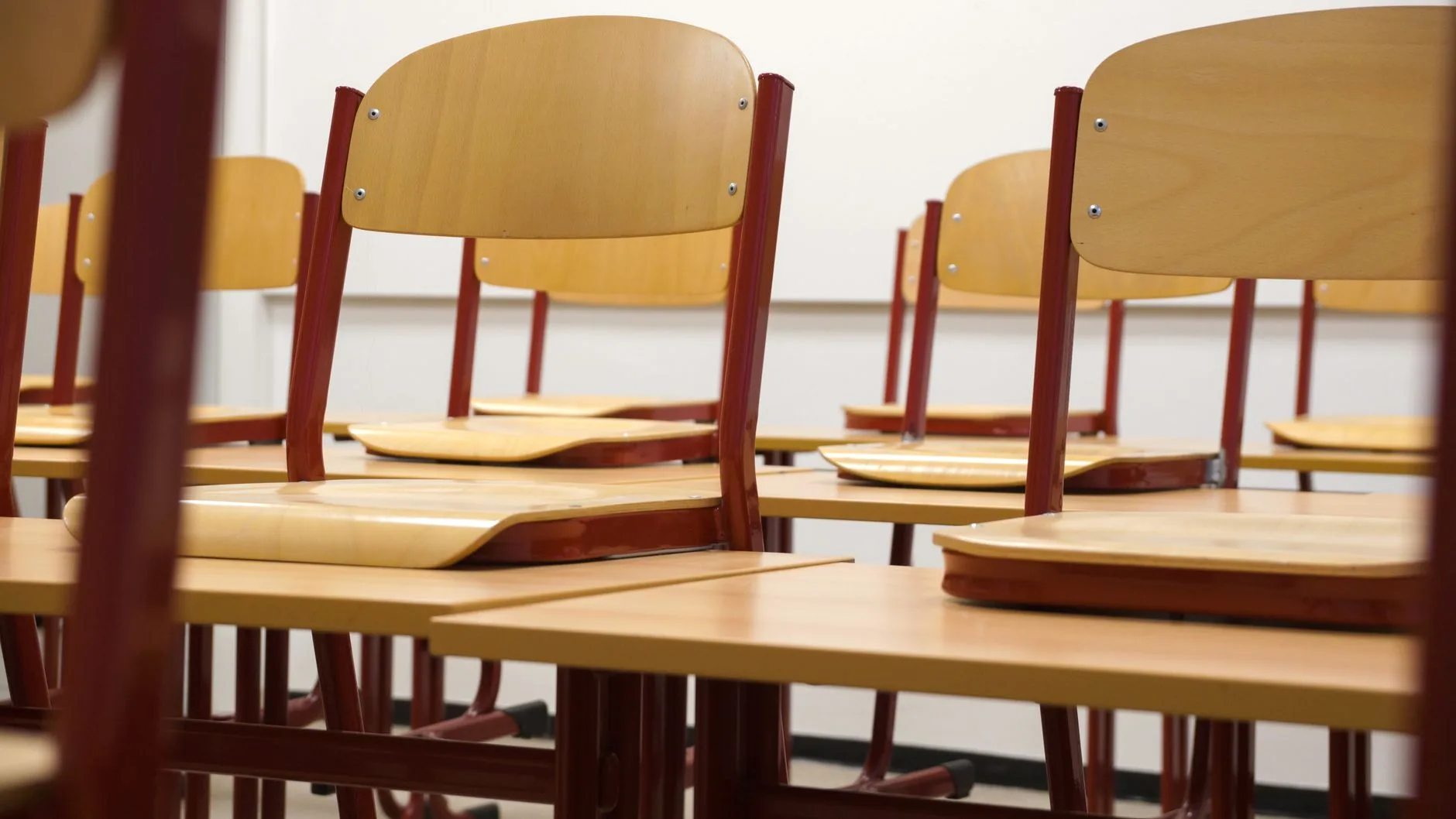 Miljöbild – classroom chairs and desks in warm light